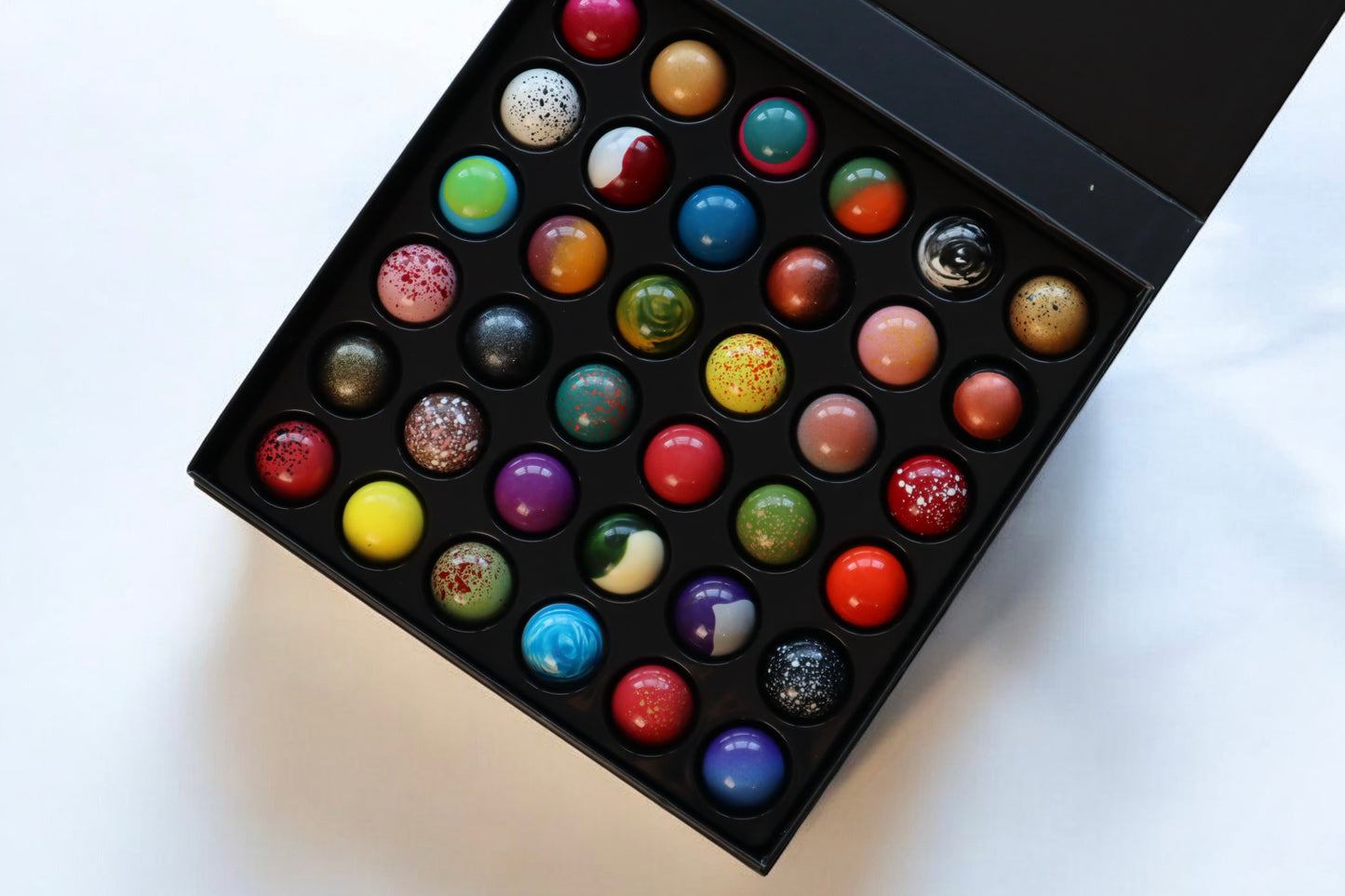 Luxurious gift box of 36 handcrafted chocolates in vibrant colors and unique designs from 1683 Chocolate Place.